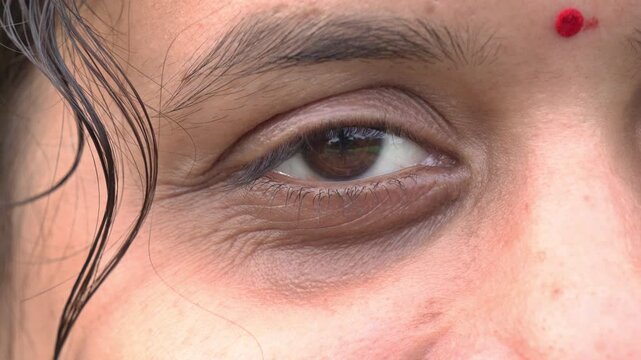 Extreme Close Up of Natural Brown Eye of an Indian Woman. Macro Shot of South Asian Female Eye with Traditional Red Bindi. Human Eye Closeup.