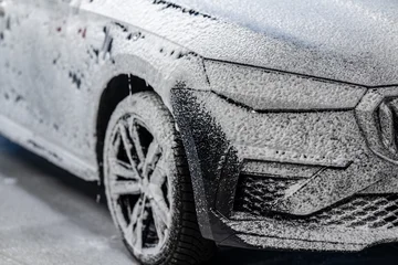 Car covered with active foam in a car wash © lightpoet