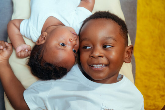 Brothers bonding with newborn sibling at home