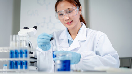 Fototapeta premium Professional scientist conducts rigorous laboratory analysis preparing blue liquid solution for medical development with advanced research equipment