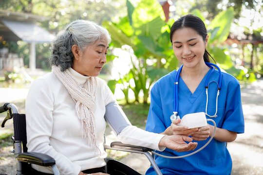 A woman in a wheelchair is being checked by a nurse