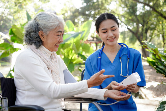 A woman in a wheelchair is being assisted by a nurse