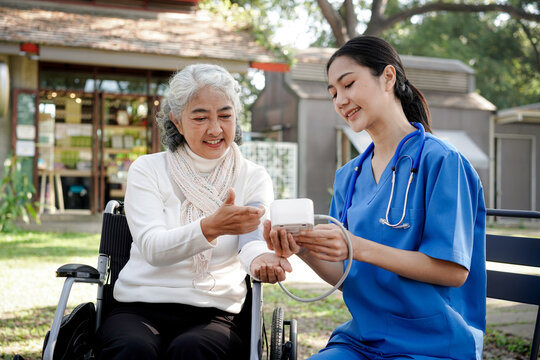A woman in a wheelchair is being helped by a nurse
