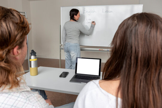Classroom lesson with students and teacher at whiteboard
