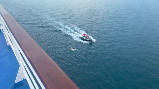 Aerial view of a high-speed harbor pilot boat underway, creating a dynamic wake as it transports maritime pilots to and from commercial vessels. Pilot boats are essential for guiding large ships safel