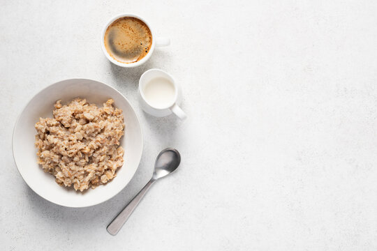 Spelt porridge and coffee. Morning breakfast routine. Grey concrete table background, top view copy space