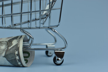 Mini shopping cart holds crumpled bills © Nazir