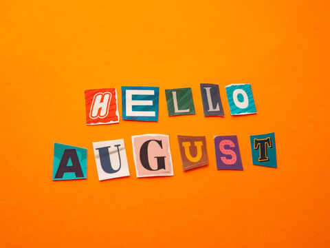 Hello August message made from colorful paper cutout letters on orange background