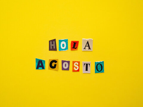 Hello August message in Spanish made from colorful paper cutout letters on yellow background