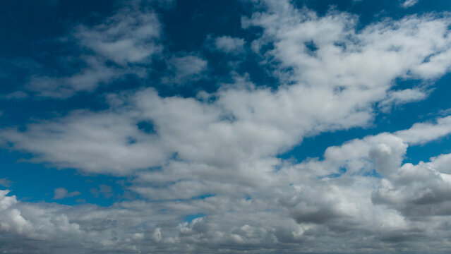 Sunny background, blue sky with white cumulus clouds