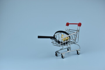Mini shopping cart holds magnifying glass © Nazir