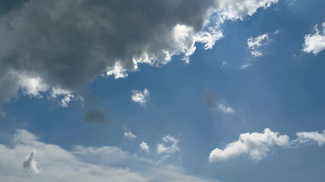 Dramatic sky with dark clouds and patches of bright blue creating a striking contrast in the atmosphere