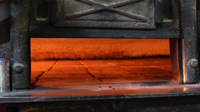 Vertical camera movement revealing a traditional bakery oven with glowing refractory bricks