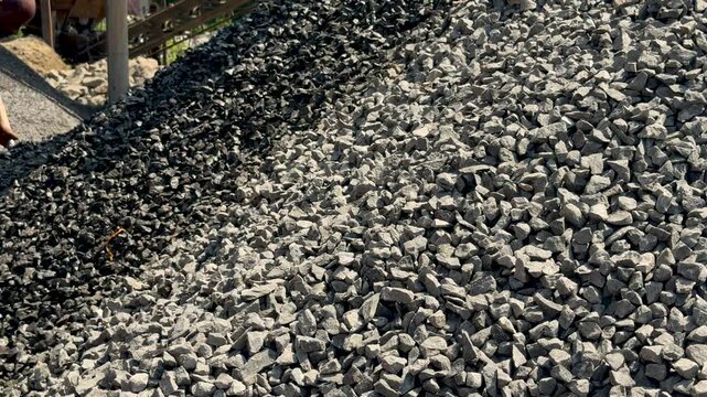 Pile of crushed stones with contrasting shades under sunlight in an industrial setting