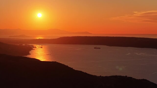 Aerial drone view of an enclosed bay at sunset with hazy headlands beyond, Chania, Greece