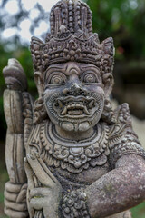 Fototapeta premium Closeup of details of stone carved statue of a god on wall of Hindu temple in Bali