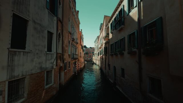 Narrow Venice canal in deep afternoon shade