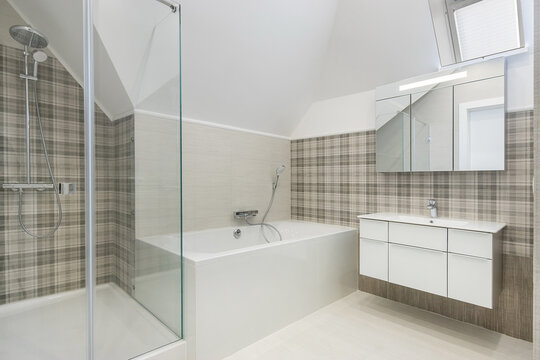Modern design of the bathroom, decorated with light gray tiles with a pattern. A small window.