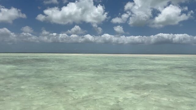 Expansive shallow flats at Christmas Island (Kiritimati), Kiribati, featuring crystal-clear turquoise water beneath towering tropical clouds. This remote Pacific destination is world famous for saltwa