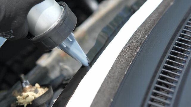 Auto glass replacement in 4K. Dispensing black bonding adhesive onto the vehicle frame to secure the new windshield glass