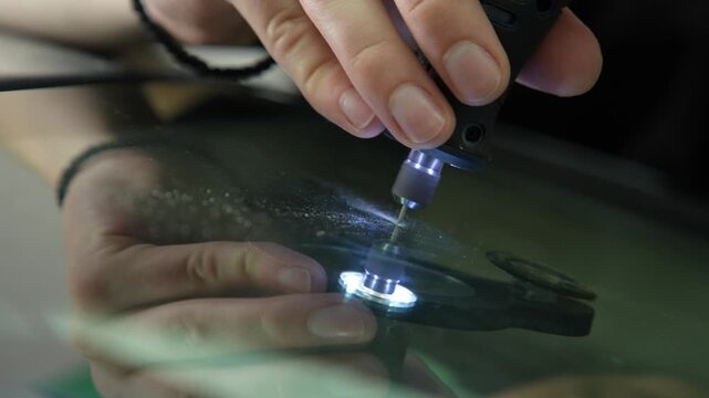 Auto glass repair 4K footage drilling into a windshield crack. Technician drilling the impact point of a glass chip to prepare for resin injection