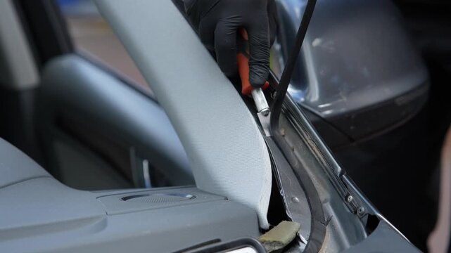 Windshield Adhesive Removal 4k video. Technician uses blade to remove old sealant from vehicle frame. Essential prep for secure glass bonding