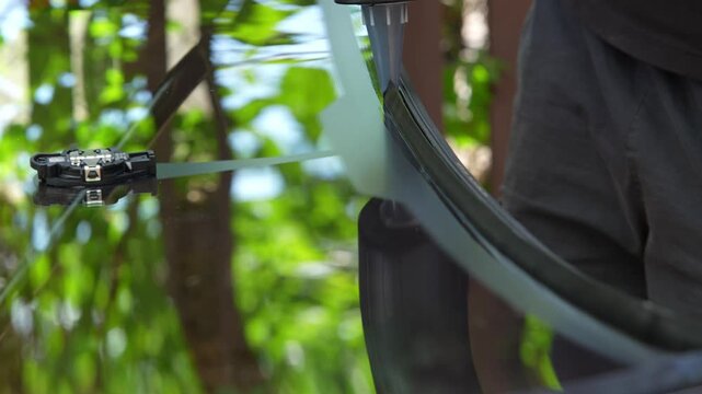 Mechanic applying a thick black urethane sealant bead along the edge of a new car windshield using a caulking gun. 4K video of extruding windshield urethane bead on glass edge