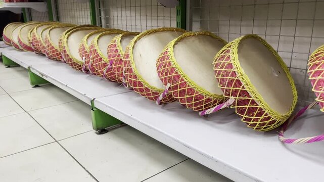 Row of traditional handmade bamboo fruit baskets displayed on a store shelf