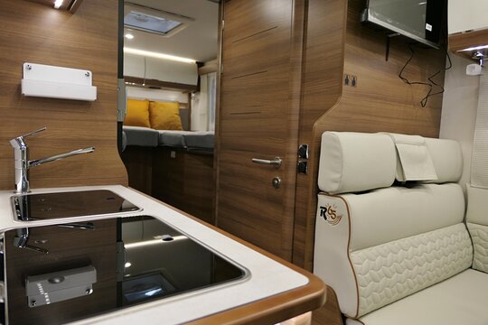 Rear part of modern luxurious french camper van Rapido  c55i, model 2026, rear seats, restroom entrance, kitchen table and beds in background visible. Displayed on Caravan Bike Travel expo in Nitra. 
