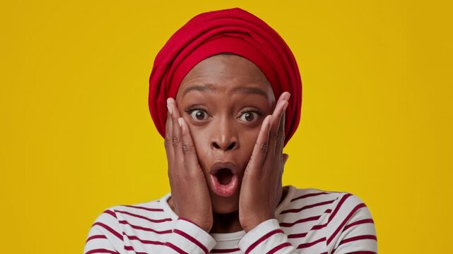 Surprised Black Woman In Her 30s Expressing Shock With Hands On Her Face, Designated Bright Yellow Background. Emotion Clearly Visible, Perfect For Various Lifestyle And Emotional Concepts.