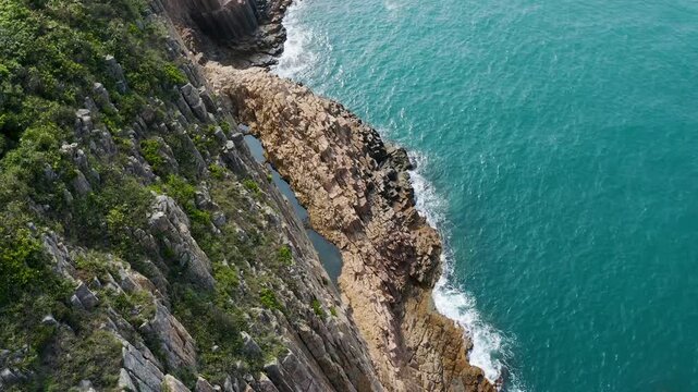 Aerial Drone Footage of Hexagonal Columnar Basalt Cliffs and Turquoise Ocean Waves Crashing on Coast