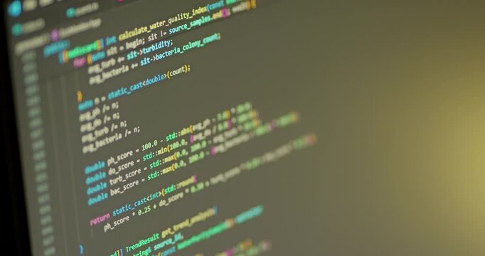 Close up of С++ programming code scrolled on the monitor. Warm IDE colors.