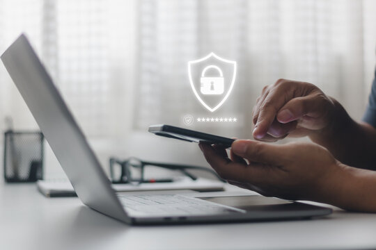 Businessman using smartphone and laptop computer with cyber security technology for protecting personal data and secure internet access. Cybersecurity and privacy concepts to protect data.