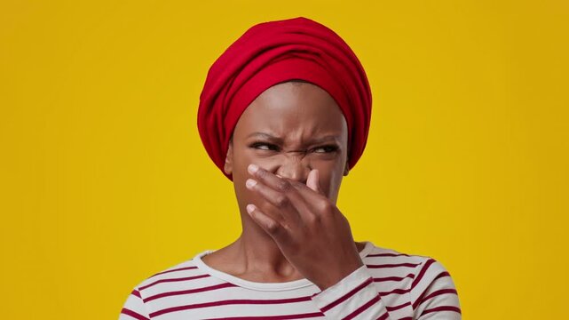 Worried Black Female Adult Scrunching Nose In Distaste, Making Facial Expression Of Displeasure, Set Against Bright Yellow Background. Capturing Emotion In Everyday Setting, Lifestyle Concept.