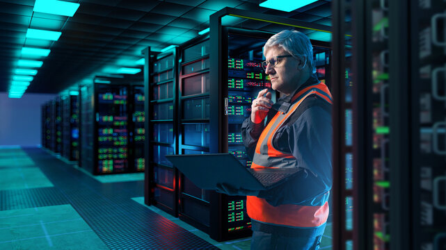 Data center operations engineer monitors server racks and network infrastructure using laptop and radio in modern server room for maintenance and control