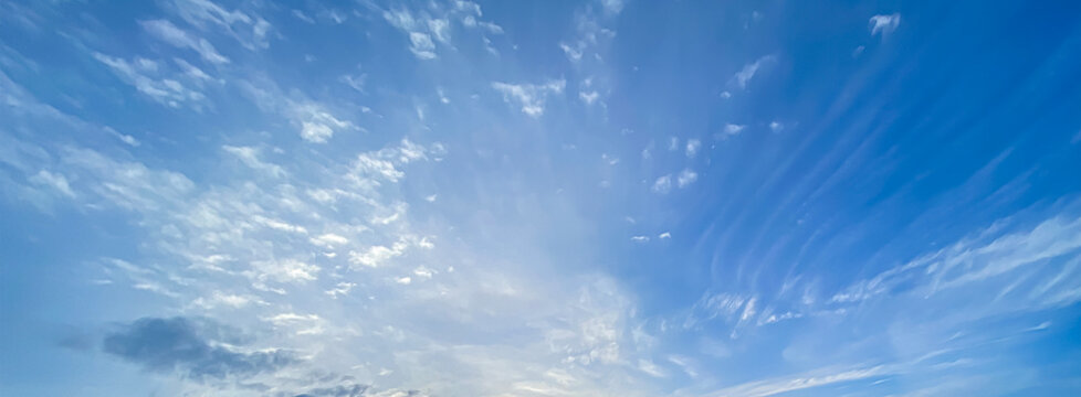 Beautiful clear blue sky background with soft white wispy cirrus and altocumulus clouds for panoramic travel mockup design