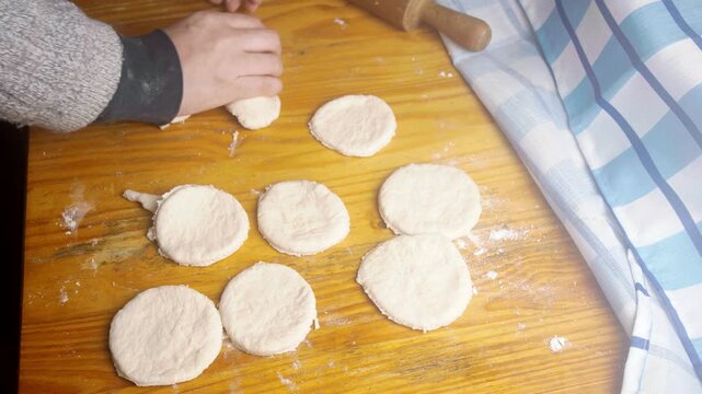 Close up of baker preparing homemade Chilean sopaipilla dough on a wooden table