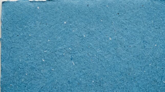 Textured blue handmade paper background with natural fibers and rough deckled edges surface.