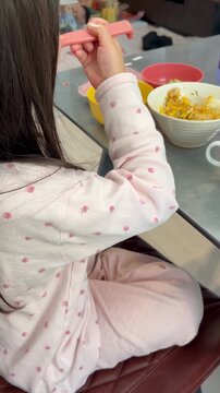 スプーンでご飯を食べる子供
