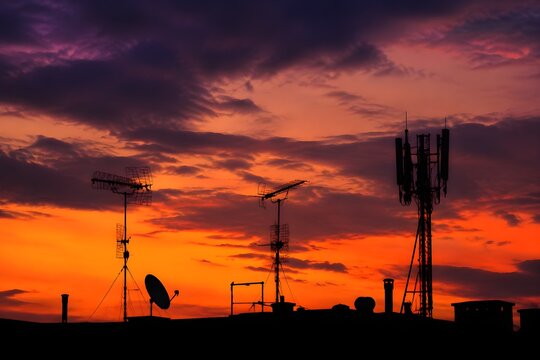 Rooftop Antennas Form Bold Silhouettes Against Dramatic Evening Sky in a Modern Urban Cityscape Scene