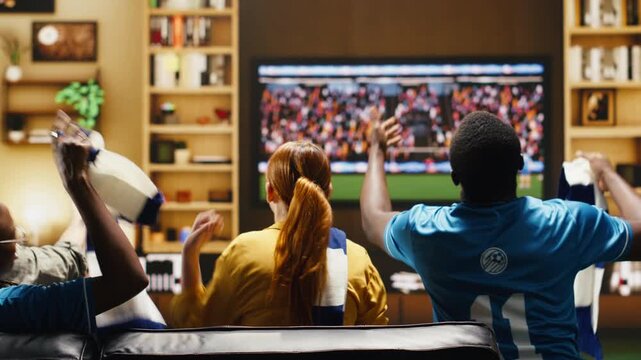 Upset football fans at home annoyed after watching missed chance during match with frustrated soccer supporters on apartment couch reacting with negative emotion during live game broadcast.