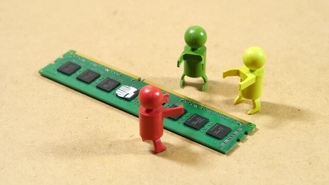 Three colorful toy figures gathered around a green desktop RAM module on beige surface, computer memory shortage, hardware supply crisis, teamwork, debate and rising component prices concept