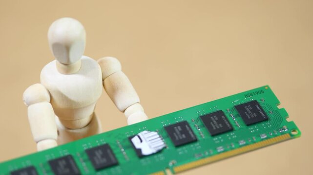 Wooden artist mannequin presenting a green desktop RAM module before collapsing on beige background, computer memory shortage, rising hardware prices, supply crisis and financial pressure concept