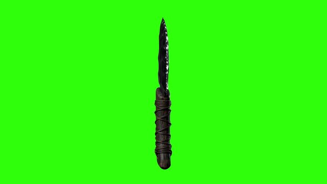 A primitive knife with a sharp dark obsidian glass blade and wrapped handle stands isolated on a green screen.