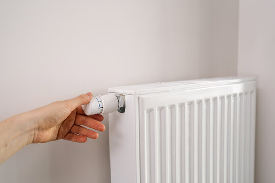 Home heating radiator adjustment in modern apartment room during winter season