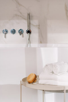 Shower gel and towels on a table near a bathtub in a hotel room