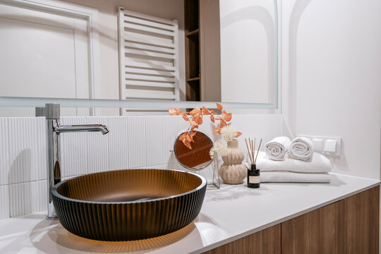 Dark glass sink and faucet in modern bathroom interior