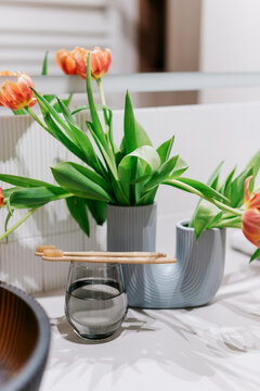 Eco-friendly bamboo toothbrushes and flowers in bathroom