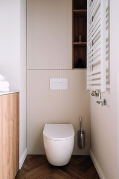Minimalist bathroom interior with wall-mounted toilet and towel heater