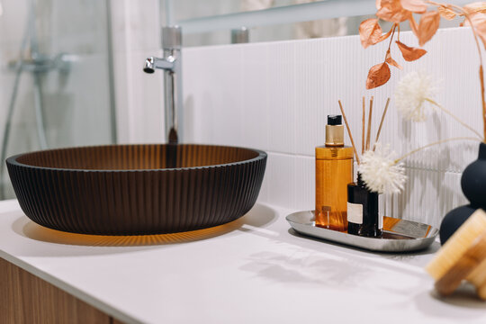 Liquid soap in dispenser bottle close to bathroom sink